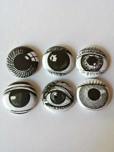 six buttons with black and white designs on them, all showing the eyeballs