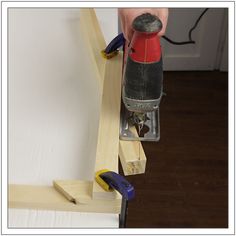 a person using a power tool to attach a piece of wood on top of a wall