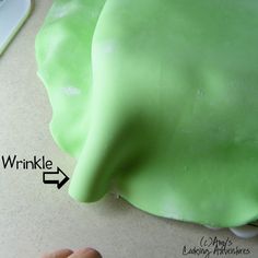 someone is decorating an elephant cake with green icing on the top and bottom