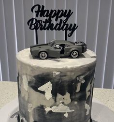 a black and white birthday cake with a car on top