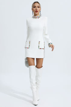 a woman wearing white boots and a dress with beaded details on the neckline