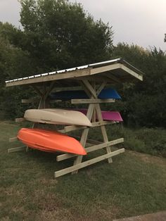 three surfboards are stacked on top of one another in the grass near trees and bushes