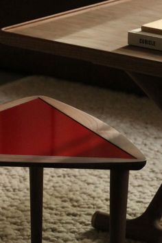 a close up of a coffee table with a book on the top and a chair in the background