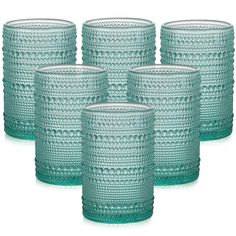 six green glass tumblers sitting next to each other