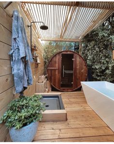 an outdoor hot tub and shower in a wooden decked area with potted plants