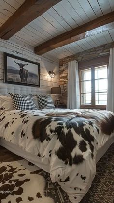 a cow print blanket on a bed in a rustic bedroom