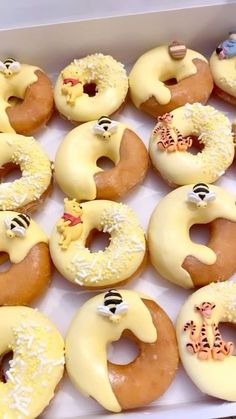 a box filled with donuts covered in frosting and decorated as cartoon animals, giraffes and zebras