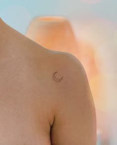 a man with a small crescent tattoo on his chest