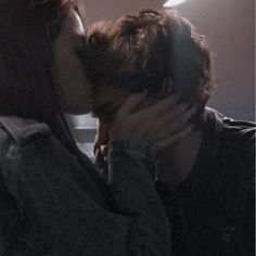 two people are kissing each other in front of a window with sunlight streaming through them