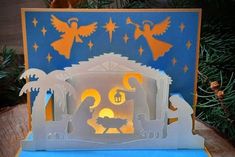 an illuminated nativity scene is displayed on a table