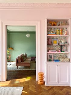 a living room filled with furniture and pink walls