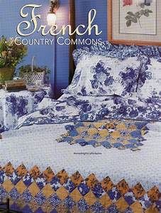 an image of a bed with blue and white comforter in the middle of it