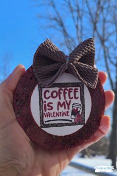 someone is holding up a cupcake with a bow on it that says coffee is my valentine