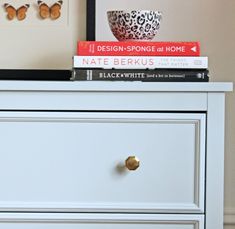 a white dresser with books on top of it