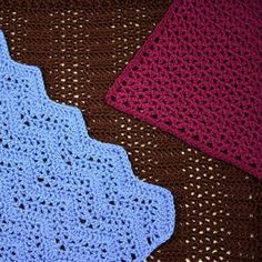 three crocheted placemats sitting on top of a brown and blue blanket