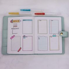 an open planner book with notes and pencils on it, next to two pens