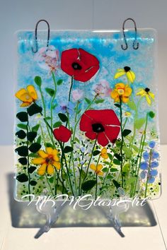 a glass plaque with flowers painted on it