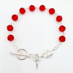 "This handmade rosary bracelet is made with 8mm ruby red Chinese crystal beads and an 10mm silver plated floral Our Father bead featuring a 0.5\" crucifix charm. All findings are silver plated. All rosary parts are made in Italy. This bracelet is 7.5 inches long. Please choose a Patron Saint Medal to add to your bracelet! (included Each bracelet in my shop is handmade by yours truly. And I back all of my work with a 100% satisfaction guarantee. If you are not completely satisfied, please contact Handmade Rosary, New Bracelet, Rosary Bracelet, Our Father, Saints Medals, Prayer Warrior, Patron Saints, Red Crystals, Photo Bracelet