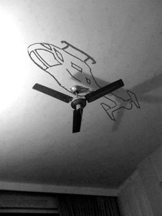 the ceiling fan is hanging from the ceiling in the room that has graffiti on it