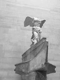 an angel statue on top of a stone structure