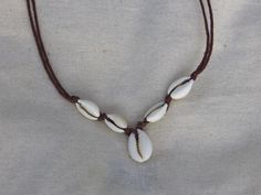 Hand-tied shell necklace on a recycled hemp blend string. Adjustable length if necessary, standard is 15 inches. Beach Necklace With Adjustable Cord In Natural Color, Brown Beach Necklace With Adjustable Cord, Natural Color Necklaces With Adjustable Cord For Beach, Natural Color Necklace With Adjustable Cord For Beach, Casual Beach Necklace With Sliding Knot, Brown Waxed Cord Beach Necklaces, Brown Waxed Cord Necklaces For The Beach, Brown Shell Necklace For Vacation, Casual Beach Jewelry Fair Trade