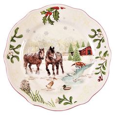 two horses standing in the snow on a plate with holly and red berries around it