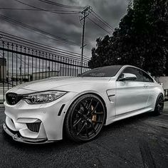 a white car parked in front of a fence