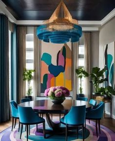 a dining room with blue chairs and a round table in front of a colorful painting