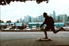 a man riding a skateboard down the street in front of a cityscape