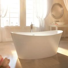 a white bath tub sitting next to two windows