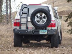 the back end of a white truck parked in a field