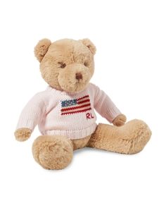 a teddy bear wearing a sweater with the american flag on it's chest, sitting against a white background