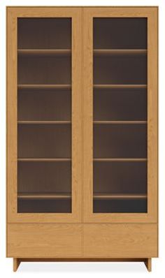 a wooden bookcase with two glass doors