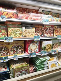 a display in a store filled with lots of different pizzas and other food items