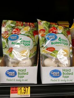 two packages of hard boiled eggs are on display for sale in a grocery store aisle