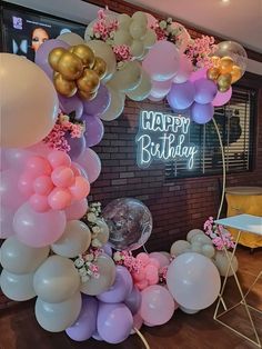 a birthday party with balloons and streamers on the wall in front of a sign that says happy birthday