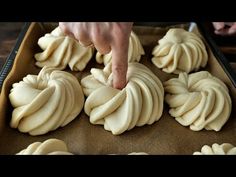 a person reaching for some kind of food on a baking tray with other foods in the background