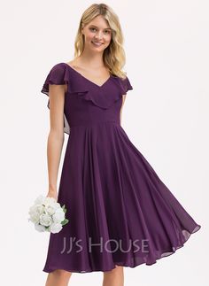 a woman in a short purple dress holding a white bouquet and posing for the camera