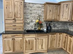 a kitchen with wooden cabinets and black counter tops