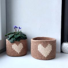 two crocheted planters sitting next to each other on a window sill