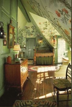 an attic bedroom with green walls and floral wallpaper on the ceiling, along with wooden furniture