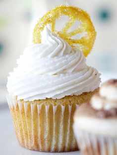 two cupcakes with white frosting and yellow icing