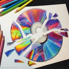 an image of a cd being cut out with colored pencils