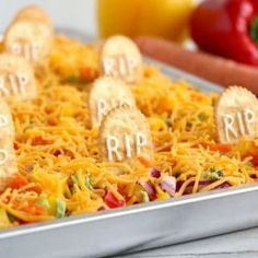 halloween treats are arranged in the shape of tombstones on top of shredded cheese and carrots