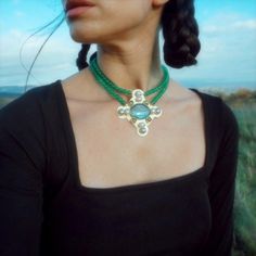 "Estrilda Choker/Necklace. Power Amulet \" My flowers are solar, my animal's horns are lunar. I'm wearing the heavens as adornment.\" Treasures from Heaven, this collection is inspired from the old jewelries of Anglo-saxons and the medieval Bizantyne style. The laden design makes these pieces unique & precious, and they add an unique look to any outfit, also they make you feel powerful. The Pendant is hand fabricated of brass and decorated with labradorite cabochon in center, peridot and labrado Bohemian Emerald Necklace Gift, Medieval Style Metal Necklaces For Larp, Handmade Bohemian Emerald Pendant Necklace, Handmade Green Byzantine Jewelry, Handmade Spiritual Emerald Pendant Necklace, Handmade Medieval Brass Necklace, Medieval Necklace Pendants, Medieval Necklace Leather, Medieval Metal Pendant Necklace