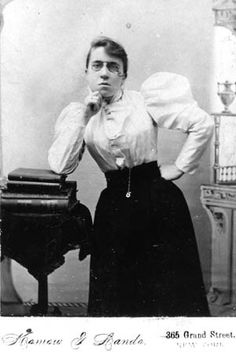 an old black and white photo of a woman posing for the camera with her hands on her chin