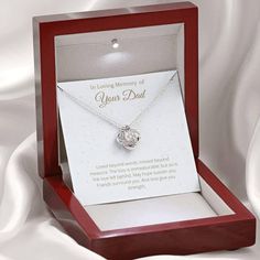 a mother - in - law necklace is displayed in a red wooden box on a white background