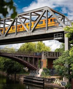 a yellow train is going over a bridge