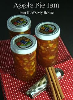 four jars filled with apple pie jam on top of a table