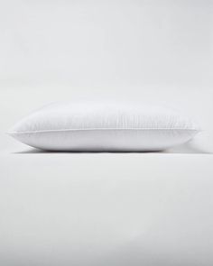 a white pillow sitting on top of a bed